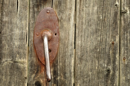 A very old door handle on a wooden doorの写真素材