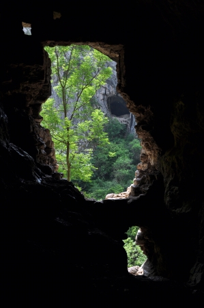 Underground cave entrance silhouette view from insideの写真素材