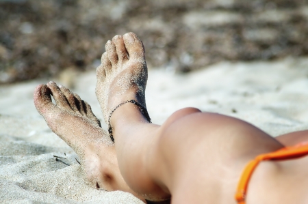 Woman's sexy feet on the beach, focus on the feetの写真素材