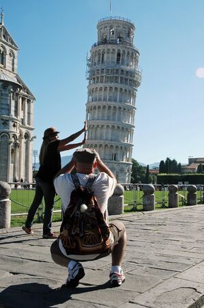 PISA, ITALY â AUGUST 31: Tourists posing in front of the Leaning tower of Pisa on August 31, 2010 in Pisa, Italy. The Leaning Tower is one of the major tourist attractions of Italyのeditorial素材