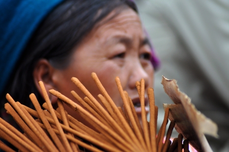 A Hmong seller woman in traditional clothes selling incense sticks in Bac Ha, Sa Pa, Vietnamのeditorial素材