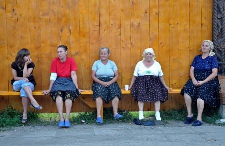 IEUD, ROMANIA - AUGUST 10: Unidentified villagers resting on a bench, in the Unesco heritage site, traditional village of Ieud. on AUGUST 10, 2012, in IEUD, Maramures, Romania のeditorial素材