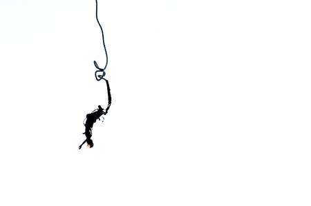 Silhouette of a bungee jumping woman isolated on white backgroundの写真素材