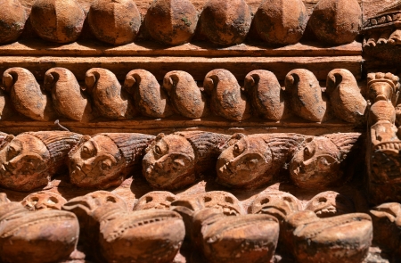 Carved wooden details, repeating heads on a Nepalese temple doorの写真素材