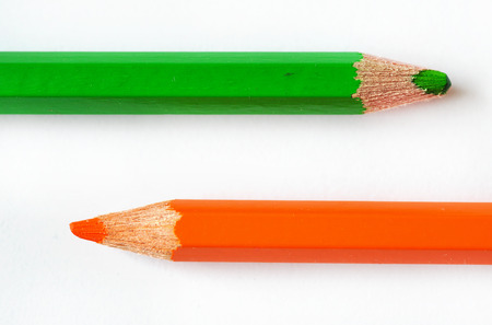 Green and orange pencil isolated on whiteの写真素材
