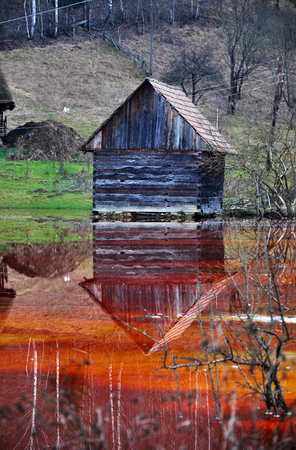 An abandoned house flooded by polluted water from a copper open cast mine の写真素材