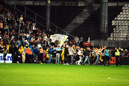 CLUJ - MARCH 4  Hooligans of the U Cluj soccer team run on the field to celebrate after their team won the first game in 42 yeras against CFR Cluj, on the opposing teamのeditorial素材