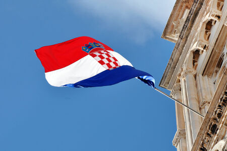 The flag of Croatia blowing in the wind on a building
