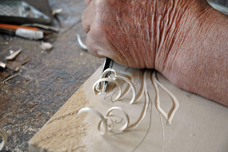 Hands of the craftsman carve a bas-relief in woodの写真素材