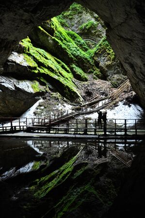 SCARISOARA, ROMANIA - AUGUST 12, 2015: Unidentified tourists visiting the Scarisoara ice cave, the largest ice cave from Europeのeditorial素材