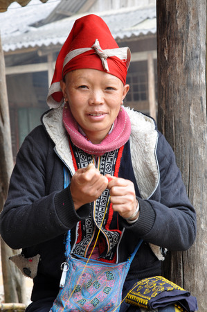 SAPA, VIETNAM - FEBRUARY 24, 2013: Unidentified Red Dao Red Yao, Dzao woman sewing in the village of Ta Phin. They are Chinese minority in Vietnamのeditorial素材