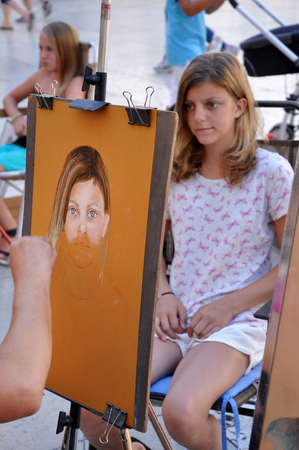 ZADAR, CROATIA - AUGUST 25, 2014: Street artist paints the portrait of a young girl on the streets of Zadar. Europe is full with street artistsのeditorial素材