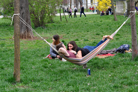 CLUJ-NAPOCA, ROMANIA - APRIL 1, 2016: Young people relaxing in hammocks in the Central park during the Big Hammock Dayのeditorial素材