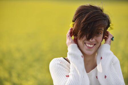 Young woman feeling happy in the middle of a canola fieldの写真素材