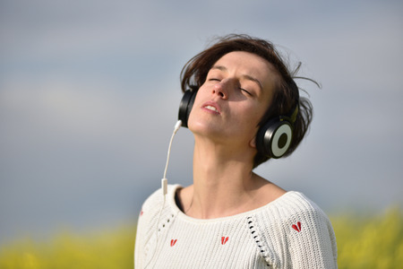 Sexy young woman with headphones dancing in the outdoorsの写真素材