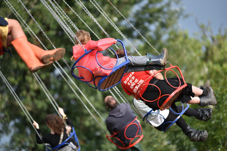 BONTIDA, ROMANIA - JULY 17, 2016: Young people enjoying swing ride, carousel, merry-go-round,...