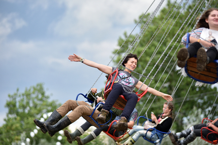 BONTIDA, ROMANIA - JULY 17, 2016: Young people enjoying swing ride, carousel, merry-go-round, highland spinner at Electric Castle Festivalのeditorial素材