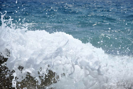 Ocean wave splashing the rocky coastの写真素材
