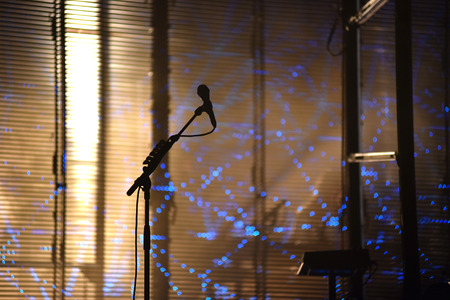 Microphone on stage with stage-lights in the backgroundの写真素材