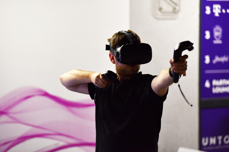 CLUJ-NAPOCA, ROMANIA - AUGUST 5, 2016: Boy tries virtual reality HTC Vive headset and hand controls during the virtual reality exposition, at the Untold Festivalのeditorial素材