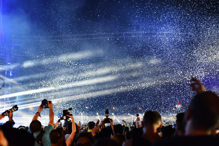 CLUJ-NAPOCA, ROMANIA - AUGUST 7, 2016: Cannons throwing confetti and streamers over partying crowd at a Dj Armin van Buuren live concert at Untold festivalのeditorial素材