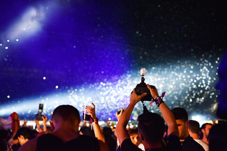 CLUJ-NAPOCA, ROMANIA - AUGUST 7, 2016: Cannons throwing confetti and streamers over partying crowd...