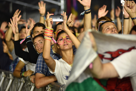 CLUJ-NAPOCA, ROMANIA - AUGUST 8, 2016: Crowd of people partying with raised arms and hands at a Afrojack concert during the Untold Festivalのeditorial素材