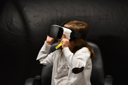 CLUJ-NAPOCA, ROMANIA - AUGUST 7, 2016: Girl tries virtual reality Samsung Gear VR headset and hand...