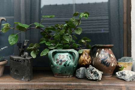 Rural house window and old jugs, clay pots and vintage ironの写真素材