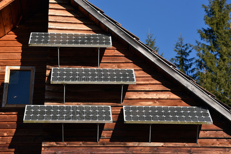 Solar panel on a wooden cottage in the forestの写真素材