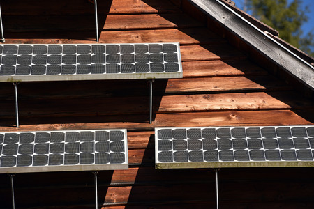 Solar panel on a wooden cottage in the forestの写真素材