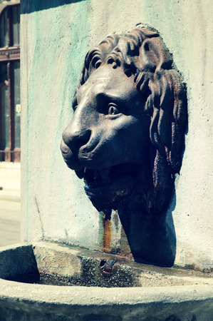 Brass fountain statue of a lion head. Toned vintage imageの写真素材
