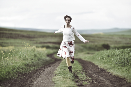 Happy girl running on a countryside road. Freedom conceptの写真素材