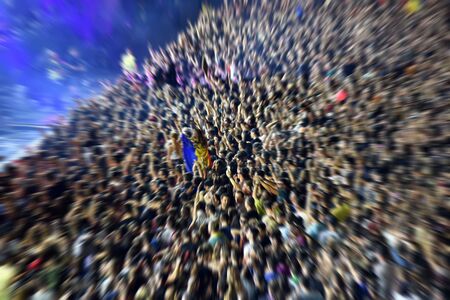 Zoom in effect on a blurred crowd partying at a music festivalの写真素材