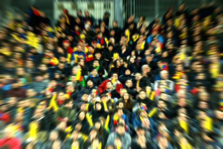 Blurred, defocused fans on a stadium tribune. Zoom in lens effectの写真素材
