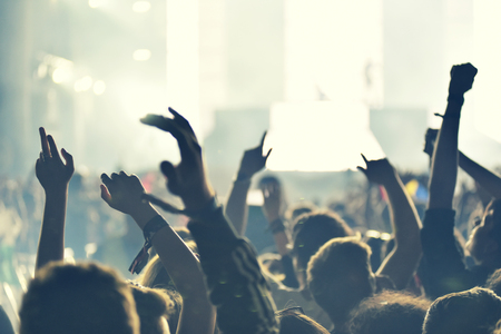 Crowd rocking during a concert with raised arms. Toned imageの写真素材