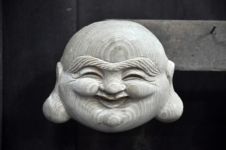 Handmade smiling Buddha wooden carved statue in Vietnamの写真素材