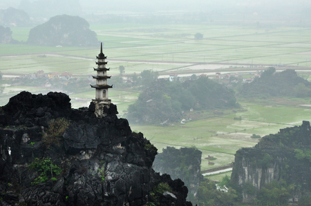Panorama view of rice fields, limestone rocks and mountaintop pagoda from Hang Mua Temple viewpoint in a rainy day. Ninh Binh, Vietnamの写真素材