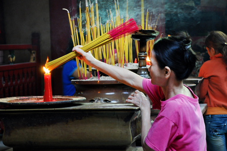 HO CHI MINH, VIETNAM - FEBRUARY 15, 2013: Asian people praying and burning incense sticks in Chua Ba Thien Hau pagoda, Saigonのeditorial素材