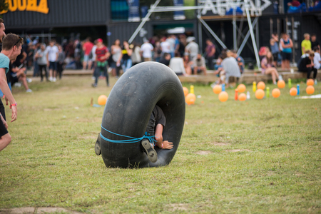 BONTIDA, ROMANIA - JULY 16, 2017: Young funny adults playing with an inner tube of a tractor at Electric Castle Festivalのeditorial素材