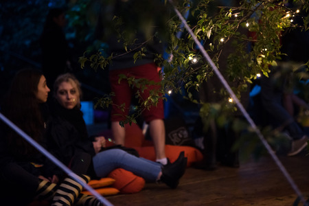 BONTIDA, ROMANIA - JULY 15, 2017: People relaxing in a special chilling natural area decorated with small led lamps at Electric Castle festivalのeditorial素材
