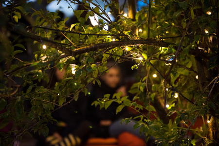 BONTIDA, ROMANIA - JULY 15, 2017: People relaxing in a special chilling natural area decorated with small led lamps at Electric Castle festivalのeditorial素材
