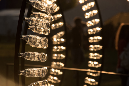 BONTIDA, ROMANIA - JULY 13, 2017: Empty Coca Cola bottles are arranged in a shape in late afternoon lights at Electric Castle festivalのeditorial素材