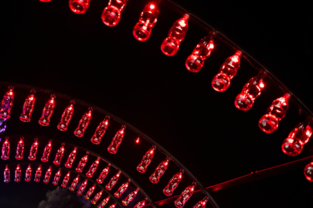 BONTIDA, ROMANIA - JULY 13, 2017: Empty Coca Cola bottles are arranged in a shape of a tunnel and illuminated with red lights at Electric Castle festivalのeditorial素材