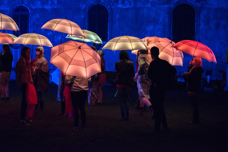 BONTIDA, ROMANIA - JULY 15, 2017: People playing with colorful umbrellas illuminated by led lamps during night at Electric Castle festivalのeditorial素材