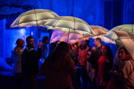 BONTIDA, ROMANIA - JULY 15, 2017: People playing with colorful umbrellas illuminated by led lamps during night at Electric Castle festivalのeditorial素材