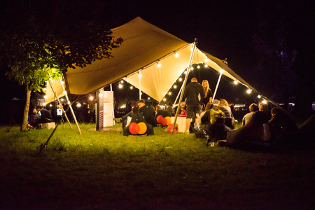 BONTIDA, ROMANIA  - JULY 13, 2017: People relaxing at night in a tent built by Mastercard during the Electric Castle festivalのeditorial素材