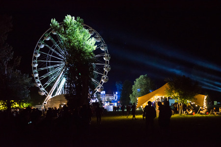 BONTIDA, ROMANIA - JULY 14, 2017: People of Electric Castle festival enjoying a ride at night on the Giant ferris wheelのeditorial素材