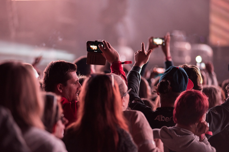 BONTIDA, ROMANIA - JULY 7, 2015: Crowd of cheering people with arms outstretched partying at an EDM...