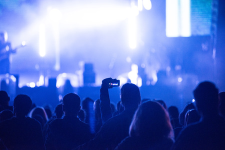 Silhouette of hands recording a concert with smart phones. Crowd of people using smart phones to photographing a concertの写真素材